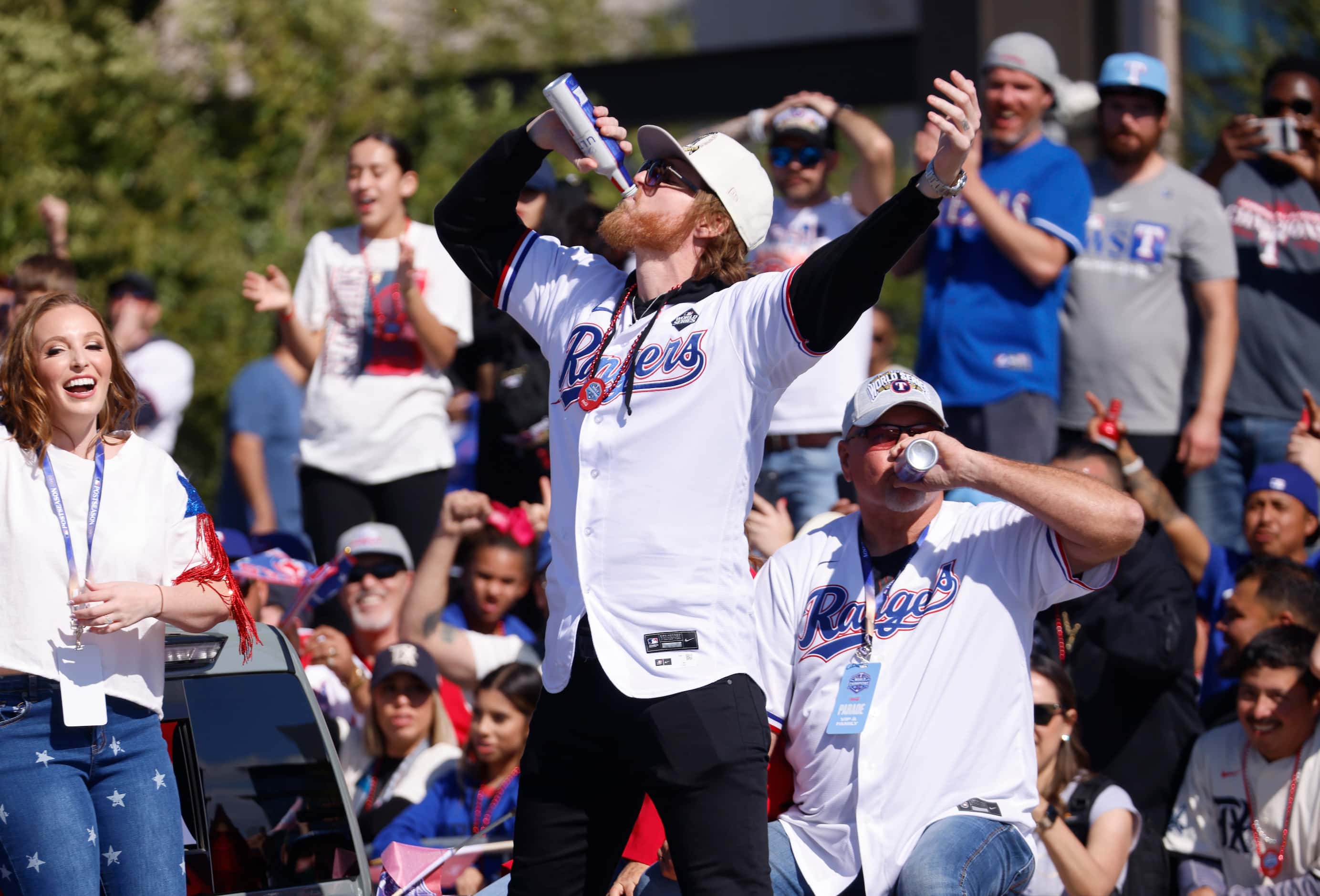 Texas Rangers pitcher Jon Gray chugs a beer before fans during a parade for the baseball...