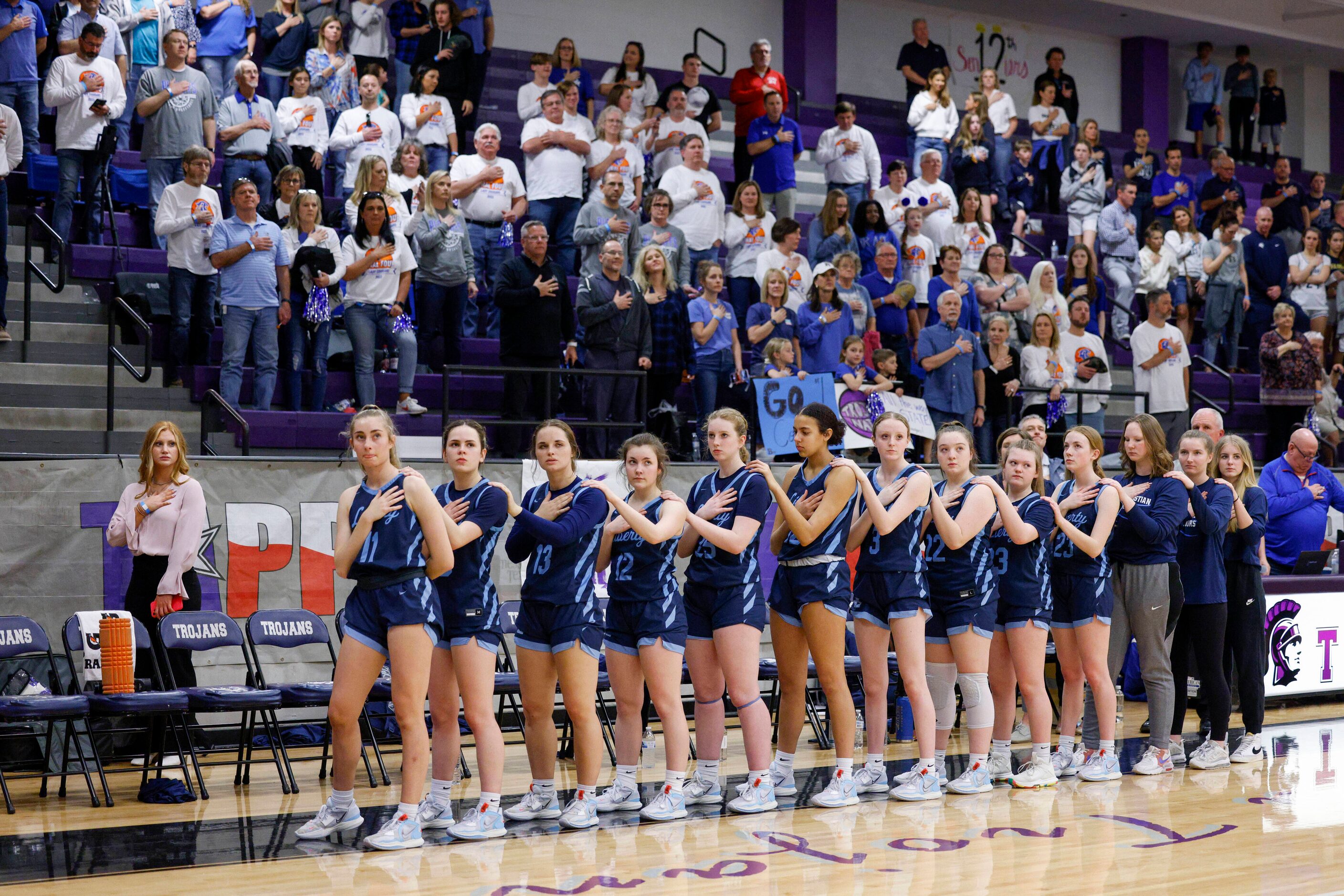 Argyle Liberty Christian players and fans stand for the national anthem before the first...