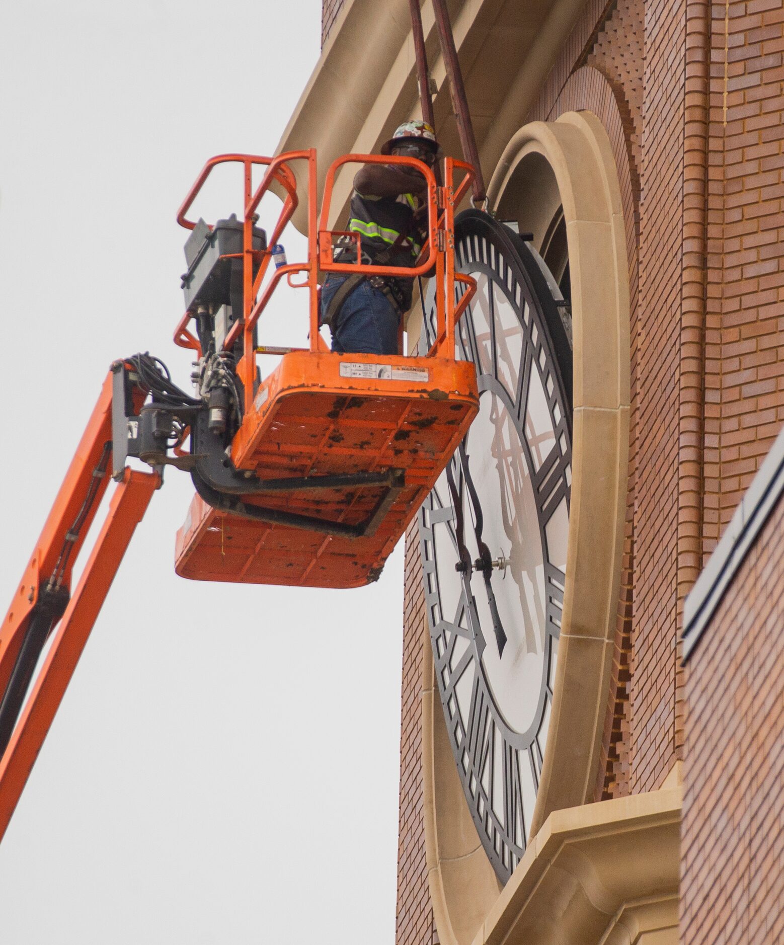 Workers from MEI Rigging & Crating work to install a 12-foot glass clock on the Grapevine...