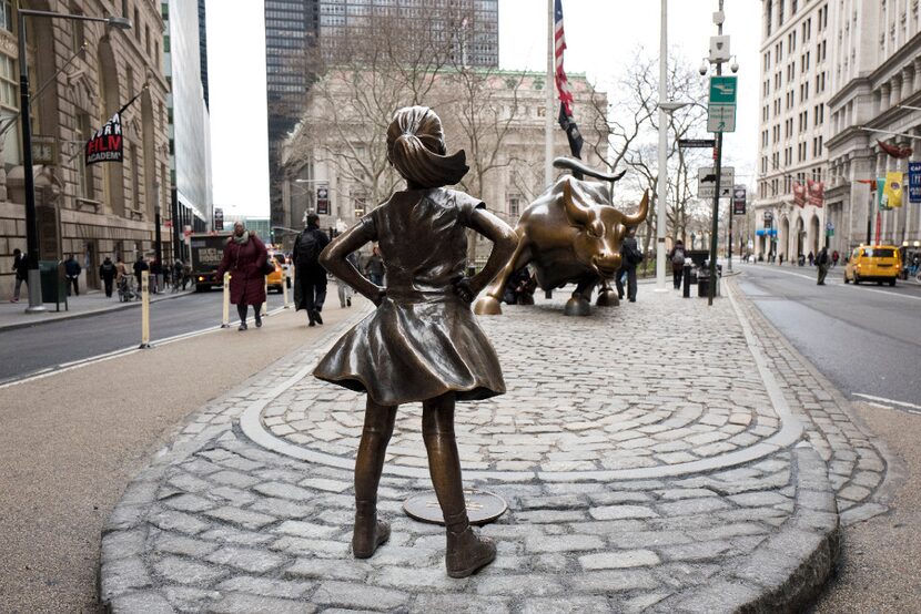 In this March 8, 2017, the "Fearless Girl" statue faces Wall Street's charging bull statue...