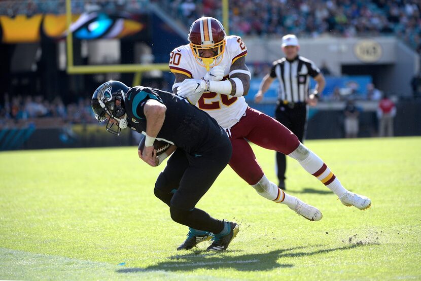 Jacksonville Jaguars quarterback Cody Kessler (6) is knocked out of bounds by Washington...