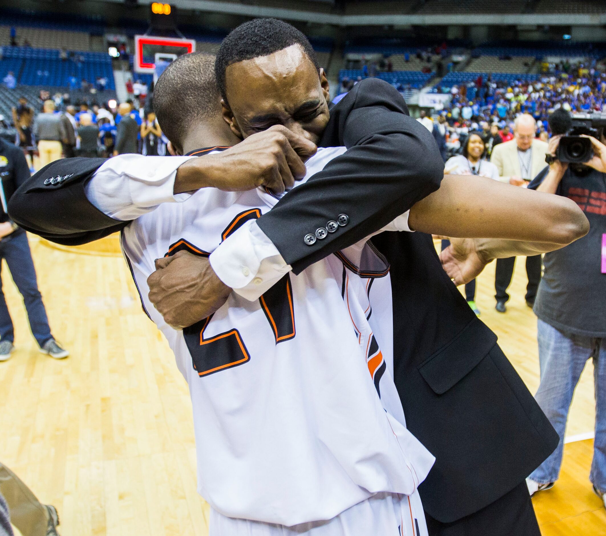 Lancaster head coach Ferrin Douglas hugs Lancaster guard/forward Brandon Moore (21) after a...