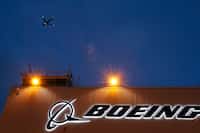 FILE - An airplane flies over a sign on Boeing's newly expanded 737 delivery center, Oct....