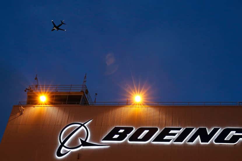 FILE - An airplane flies over a sign on Boeing's newly expanded 737 delivery center, Oct....