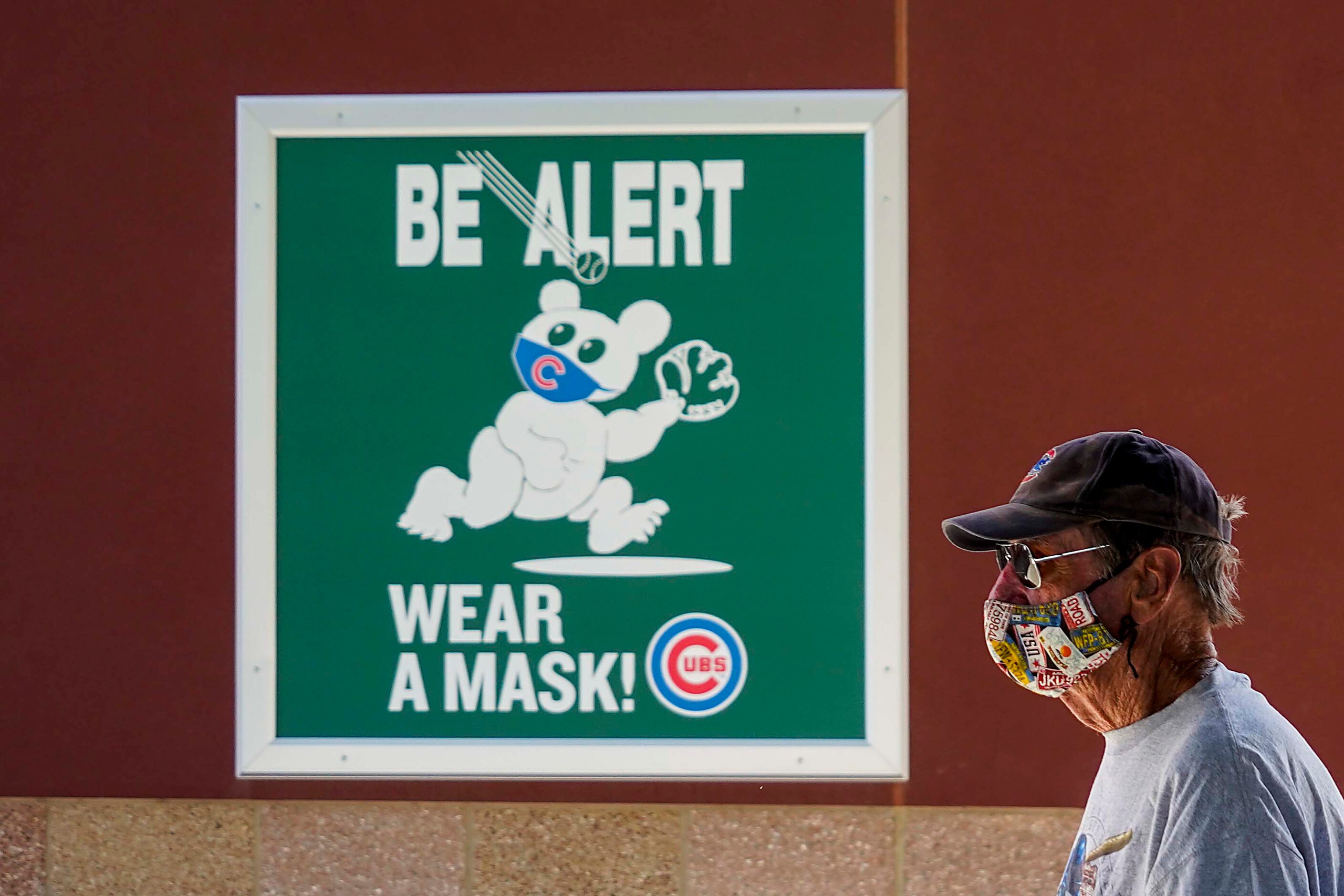 Signs encourage fans to wear face coverings during a spring training game between the...