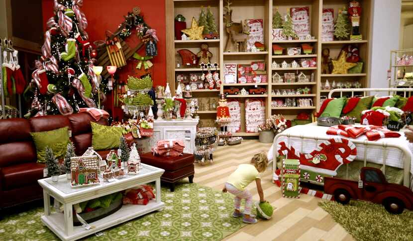 Harlow Wattenburger, 3, is seen in a holiday decor merchandise area with a variety of...