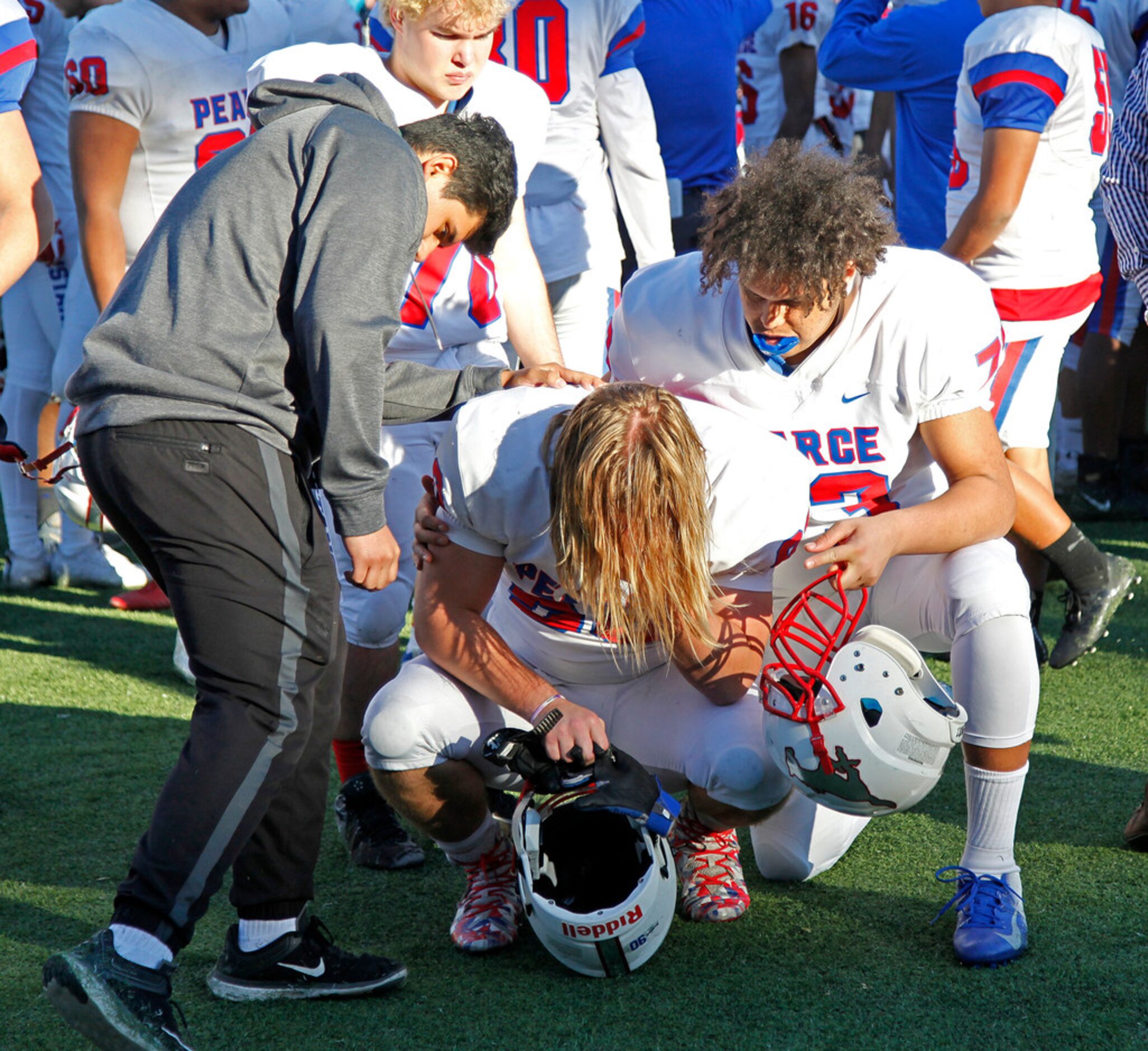 Pearce High School defensive lineman Josh Horlick (90) is comforted by team mate Pearce High...