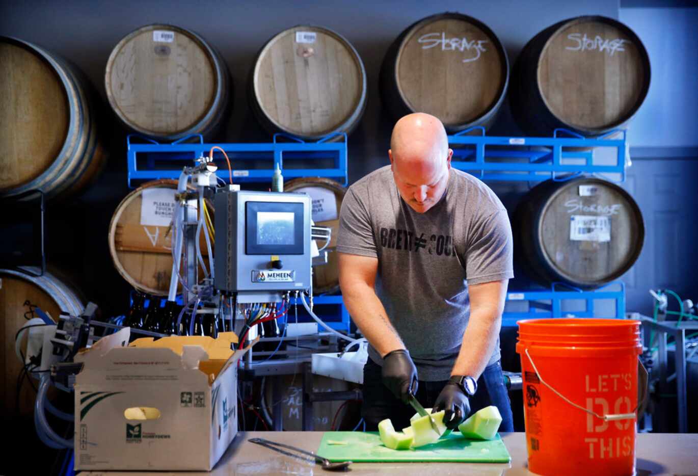 Collective Brewing Project co-founder Ryan Deyo cuts and makes a honey dew puree they will...