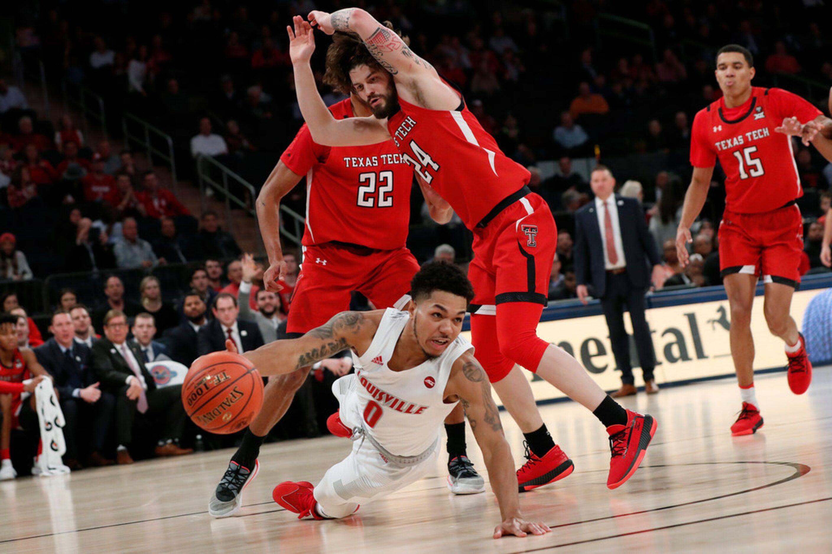 Louisville guard Lamarr Kimble (0) tries to pass after falling with Texas Tech forward TJ...