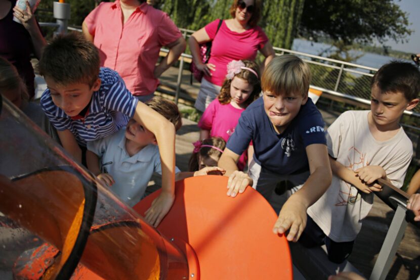 (From left) Jason Fowler, Jake Newell, David Burke and Henry Kern work an Archimedean screw...