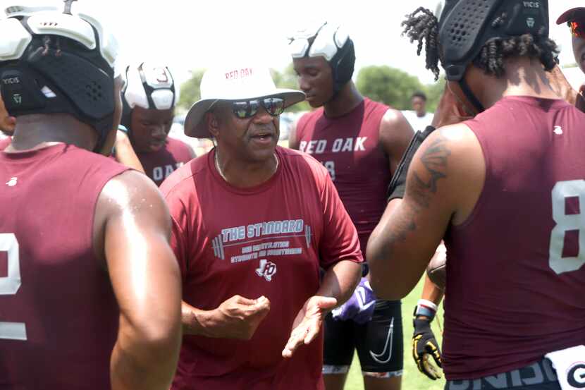Red Oak head coach Melvin Robinson, center, shares encouragement to his players during...