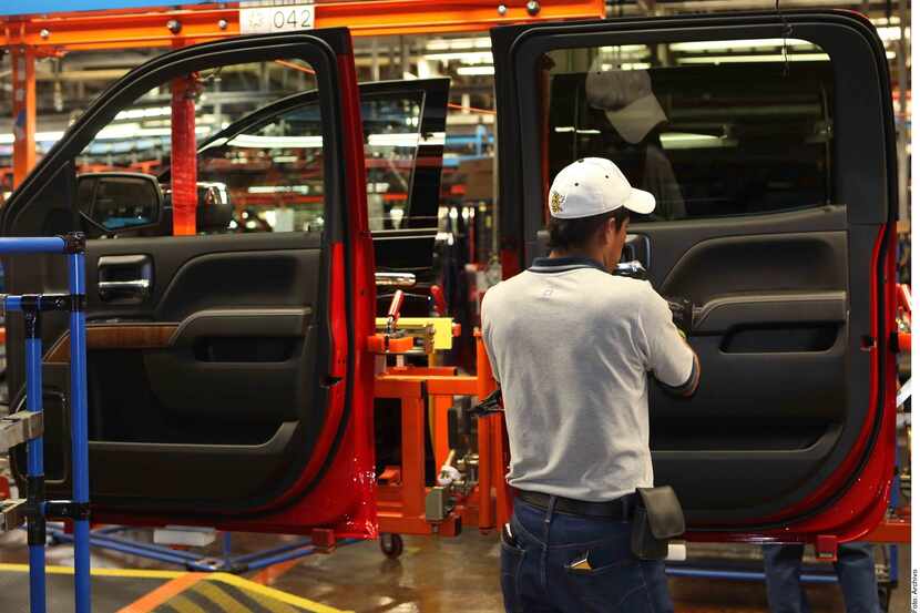 Un trabajador revisa las puertas de un vehículo ensamblado en una planta automotriz en México