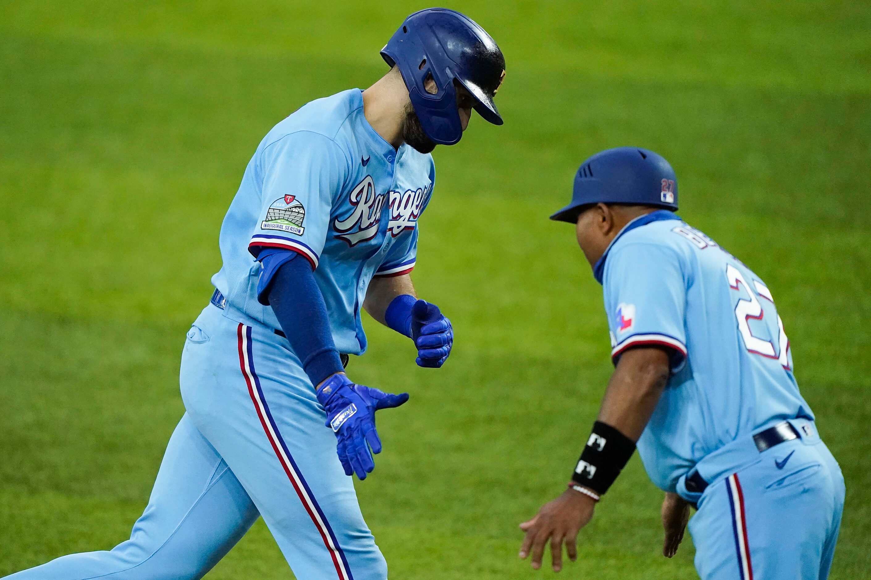 Texas Rangers outfielder Joey Gallo gets a hand from third base coach Tony Beasley as he...