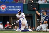 Texas Rangers right fielder Adolis Garcia (53) falls to the ground after a swing during the...