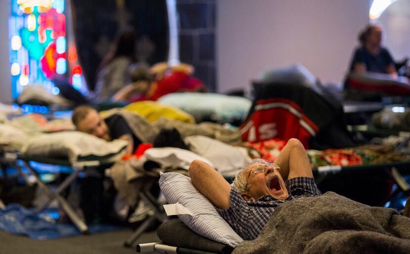 Evacuees rest on cots in a shelter at Woodcrest Church after their homes were damaged from...