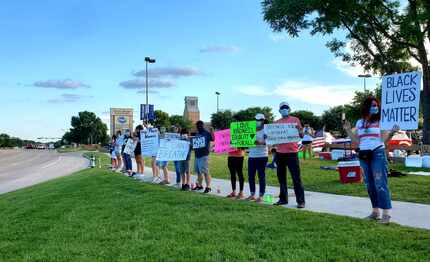 Residents gather alongside Long Prairie Road in Flower Mound on Thursday, June 4, 2020, to...