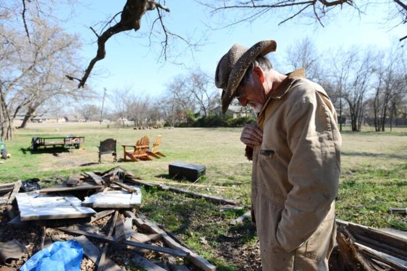 
Chris Mayes stands in his backyard among scraps of wood he uses for his wood projects at...