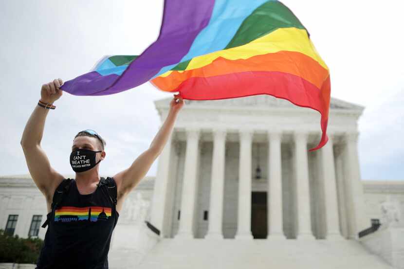 Joseph Fons, holding a Pride Flag, stands in front of the U.S. Supreme Court building after...