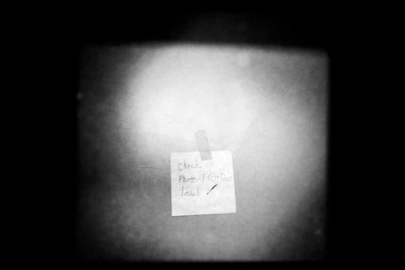 An old reminder note on a darkroom door was written years ago by a former employee.
