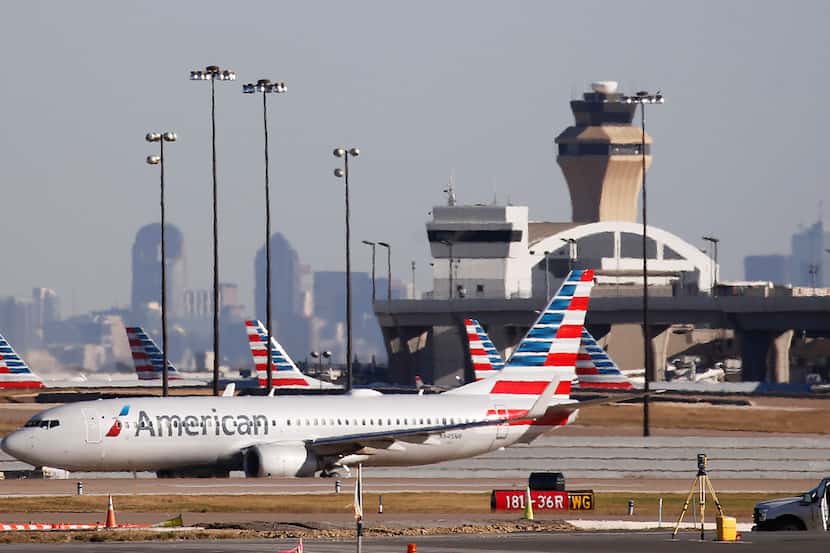 An American Airlines plane makes its way toward the runway before taking off at DFW...