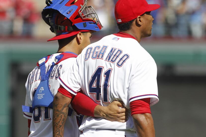Texas Rangers catcher Robinson Chirinos (61) and pitcher Alexi Ogando (41) celebrate after...