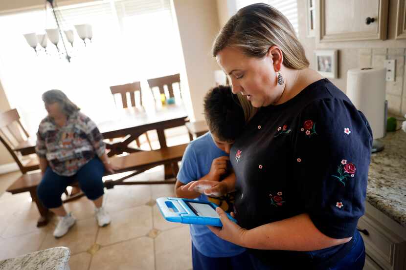 Shannon Cooper works on restoring the connectivity to her son Creighton’s tablet. Cooper...