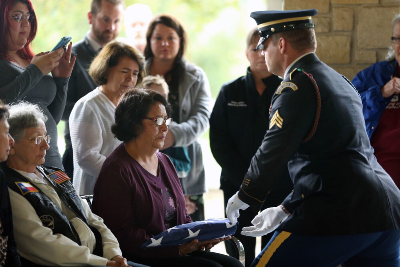 Lydia Bissell, wife of U.S. Army veteran Charles Bissell, receives a flag during a funeral...