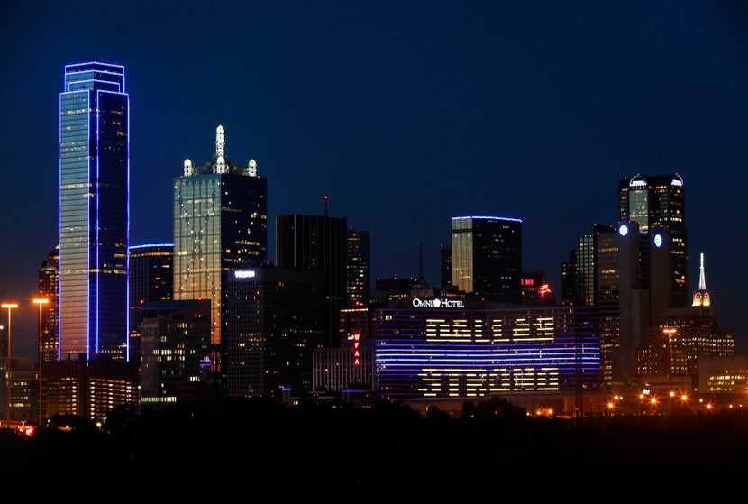 The Omni Dallas Hotel (right) reads "Dallas Strong" as the skyline of Dallas is aglow in...