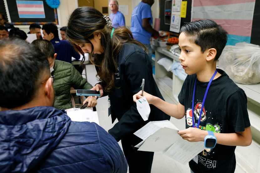 9-year-old Asher Vargas works alongside volunteer coordinator Catalina Muñiz as they...