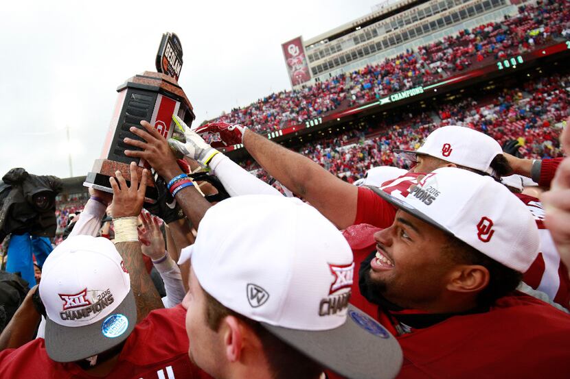 NORMAN, OK - DECEMBER 3: Members of the Oklahoma Sooners hold up the Bedlam Trophy after the...