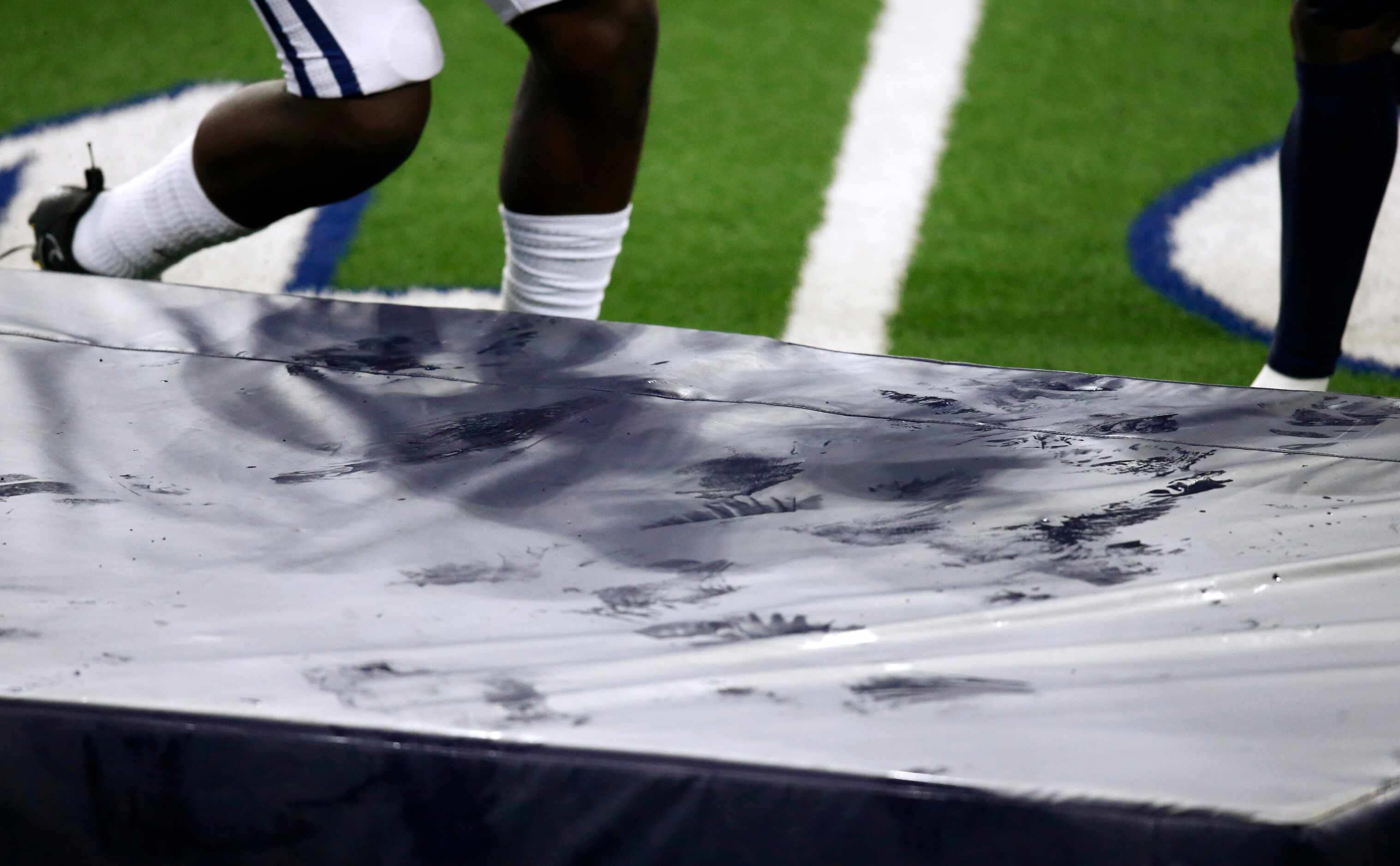 Sweat reflects off a padded cushion used for a tackling drill in practice during training...