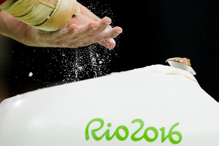 USA gymnast Madison Kocian of Dallas chalks her hands before practicing on the balance beam...