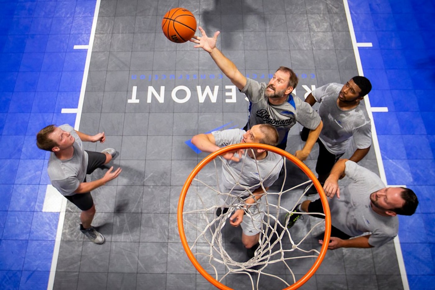 Paul Camp (top) reaches for a rebound during a basketball game with, Kevin Mezger (left),...