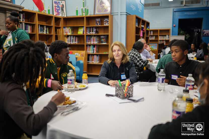 Volunteers spend time with high school students at a career day event.