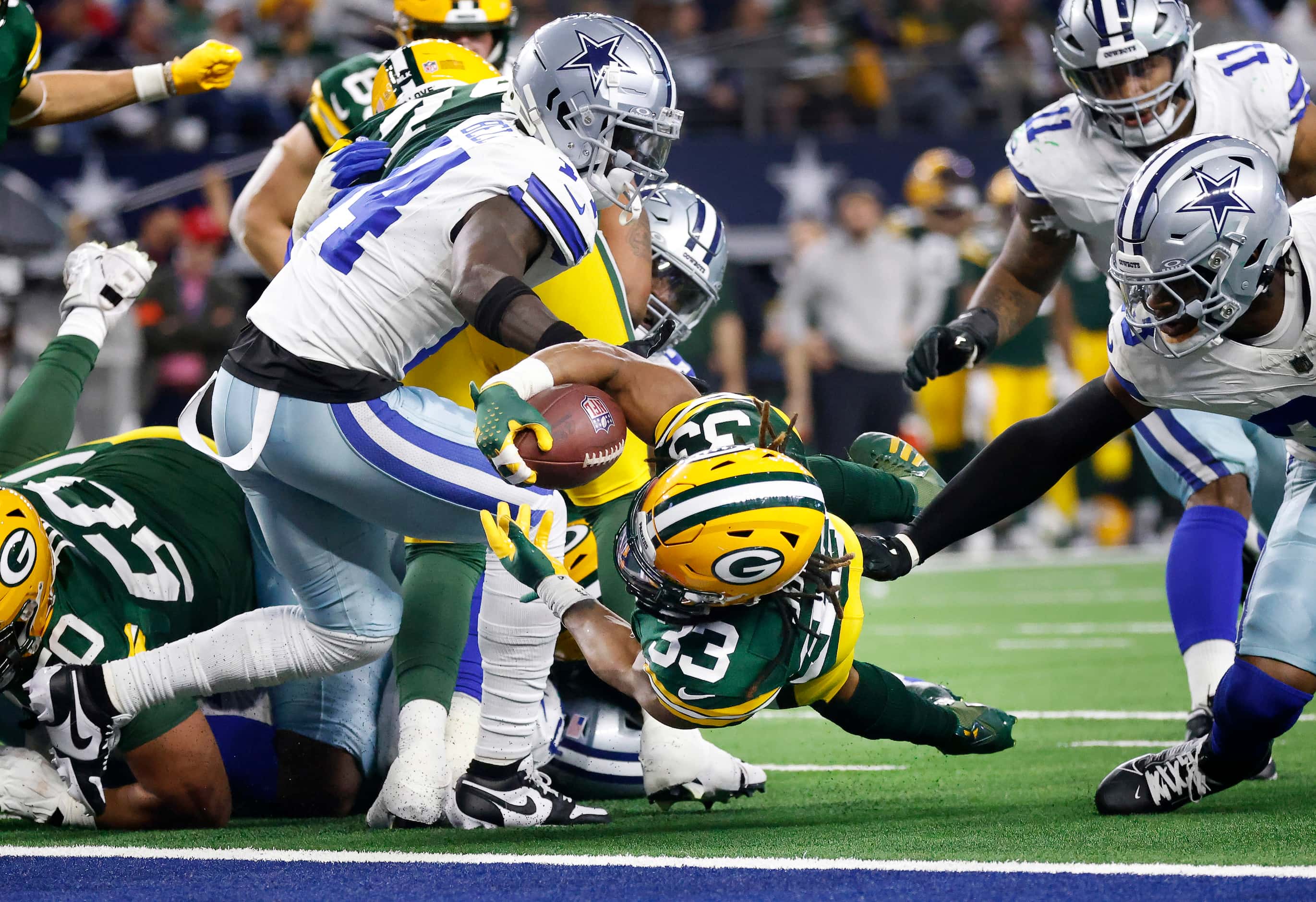Green Bay Packers running back Aaron Jones (33) rolls off the end of the line and dives for...