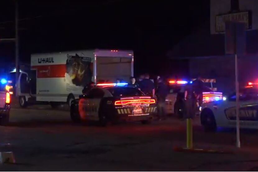 Dallas police and Dallas County Sheriff's Department officers gather around a U-Haul truck...