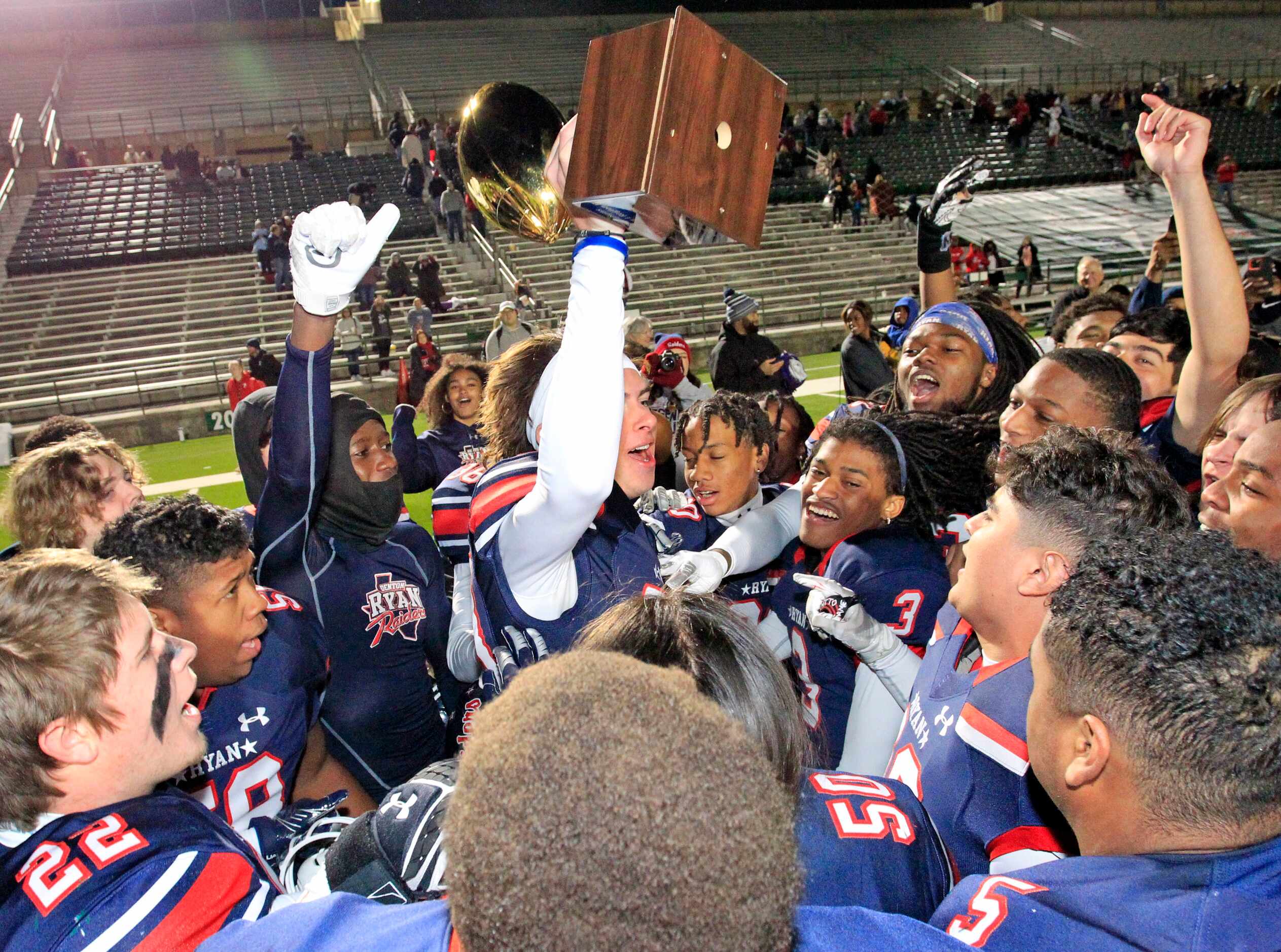 Denton Ryan K Clayton Roblyer (83) holds the game trophy high, after the Ryan coach...