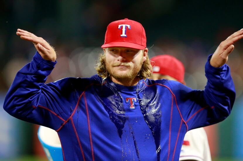 Texas Rangers starting pitcher A.J. Griffin gestures after receiving the postgame gum ball,...