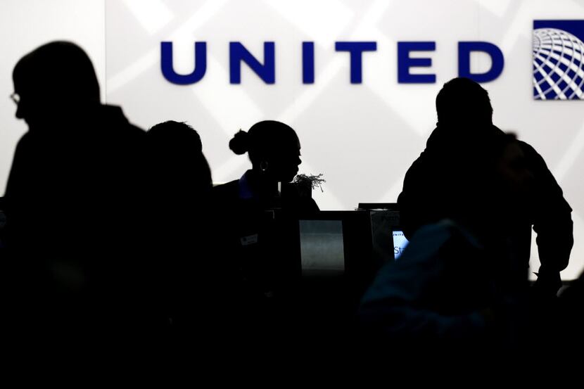 FILE - In this Saturday, Dec. 21, 2013, file photo, travelers check in at the United...