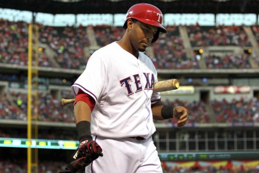 Texas right fielder Nelson Cruz walks back to the dugout after striking out in the fifth...