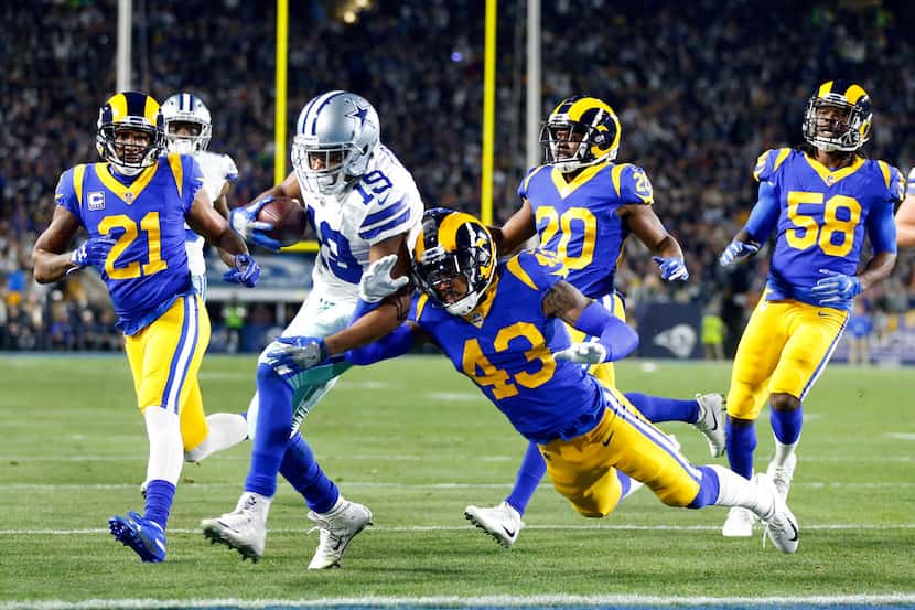 FILE - Cowboys receiver Amari Cooper (19) scores a touchdown as he bounces off Rams safety...