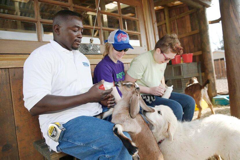 
Patrick Wright shows Janet Butler (center) and Elizabeth Gibson, both 16, how to feed baby...