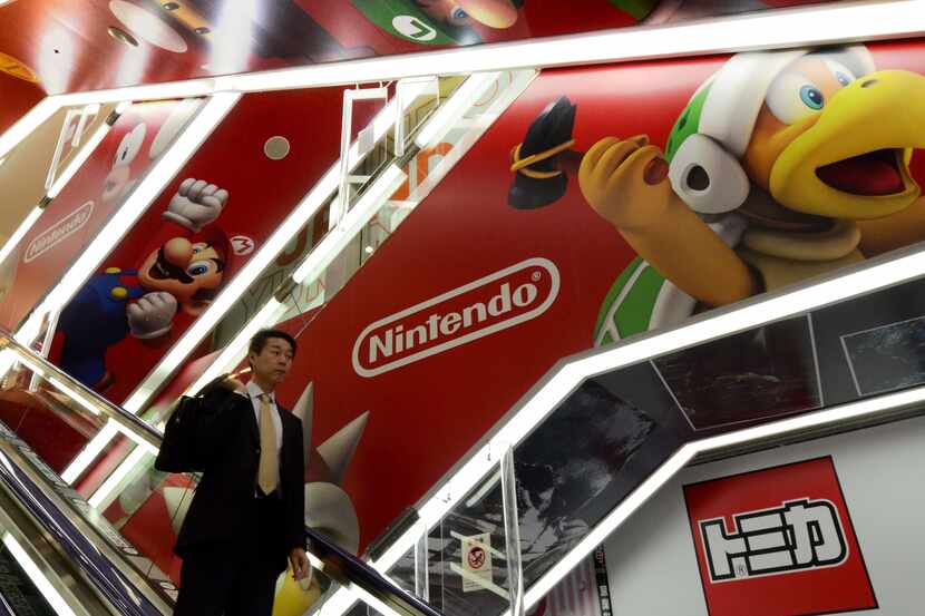 A man passes before an advertisement of Japanese video game giant Nintendo at an electronic...