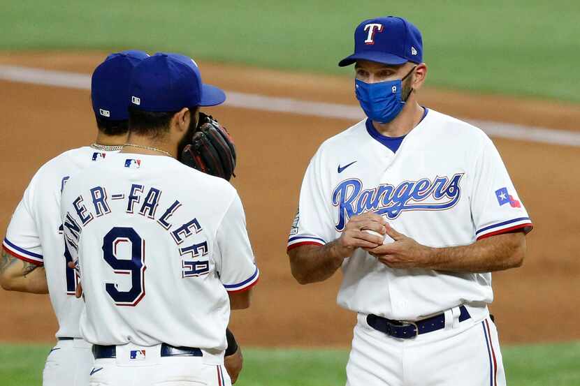 Texas Rangers manager Chris Woodward (right) visits with shortstop Isiah Kiner-Falefa (9) on...