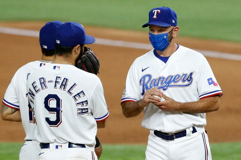 Texas Rangers manager Chris Woodward (right) visits with shortstop Isiah Kiner-Falefa (9) on...