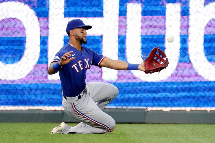 Texas Rangers center fielder Leody Taveras is unable to catch a hit by Kansas City Royals'...