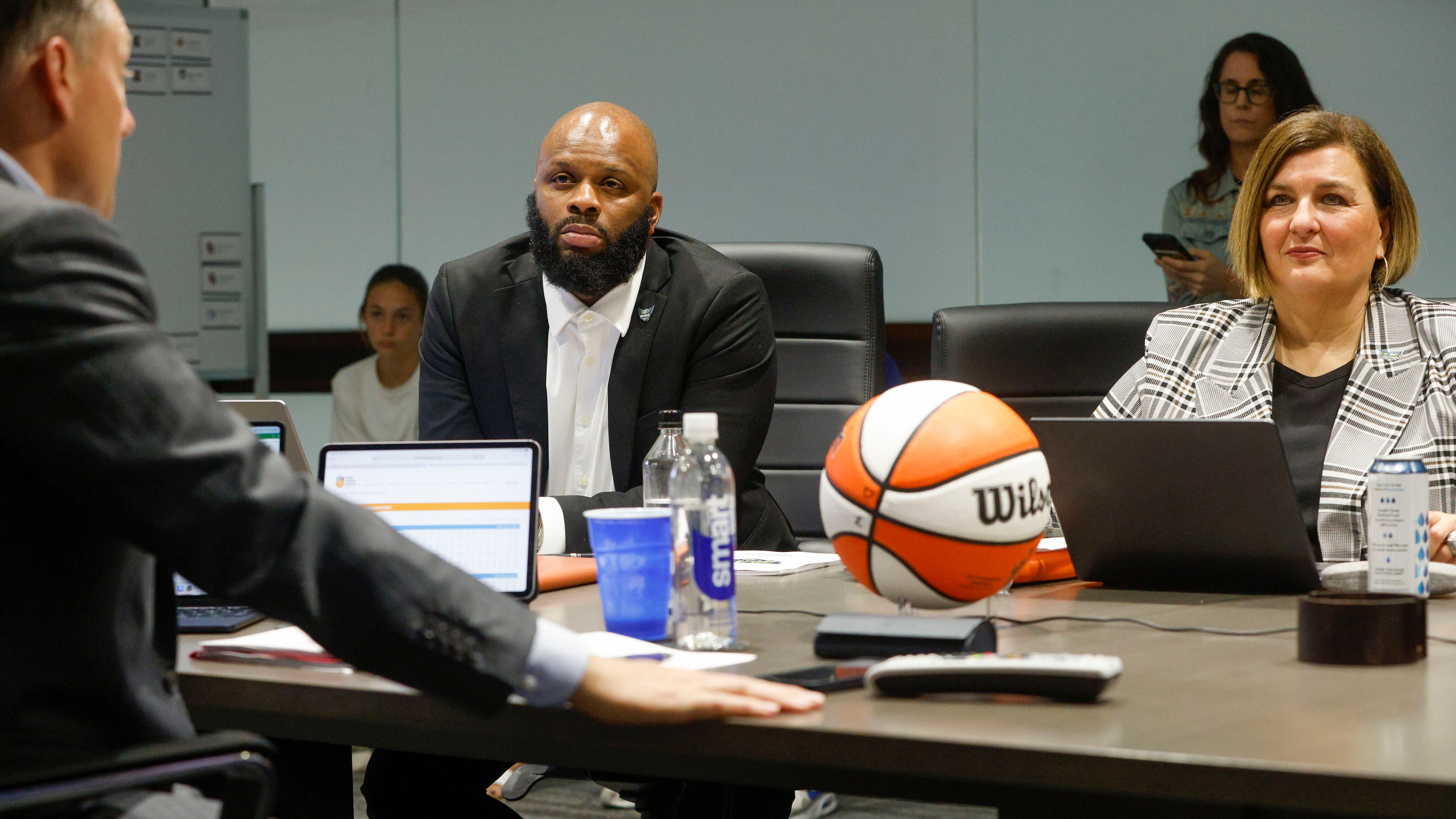 Dallas Wings assistant general manager Travis Charles (center) and head coach Latricia...