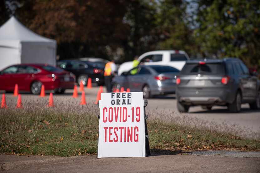 Cars wait in line to receive a COVID-19 oral testing kit at the Good Street Baptist Church...