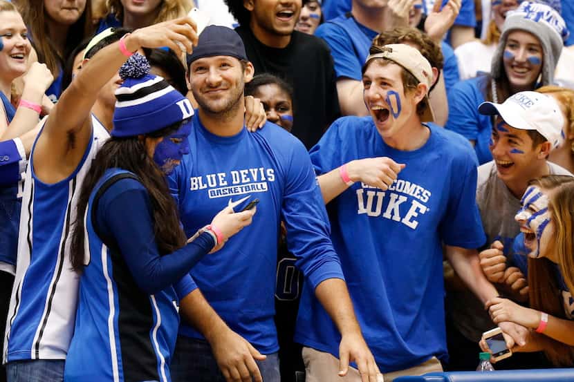 Dallas Cowboys quarterback Tony Romo, center left, poses as Duke fans take selfies with him...