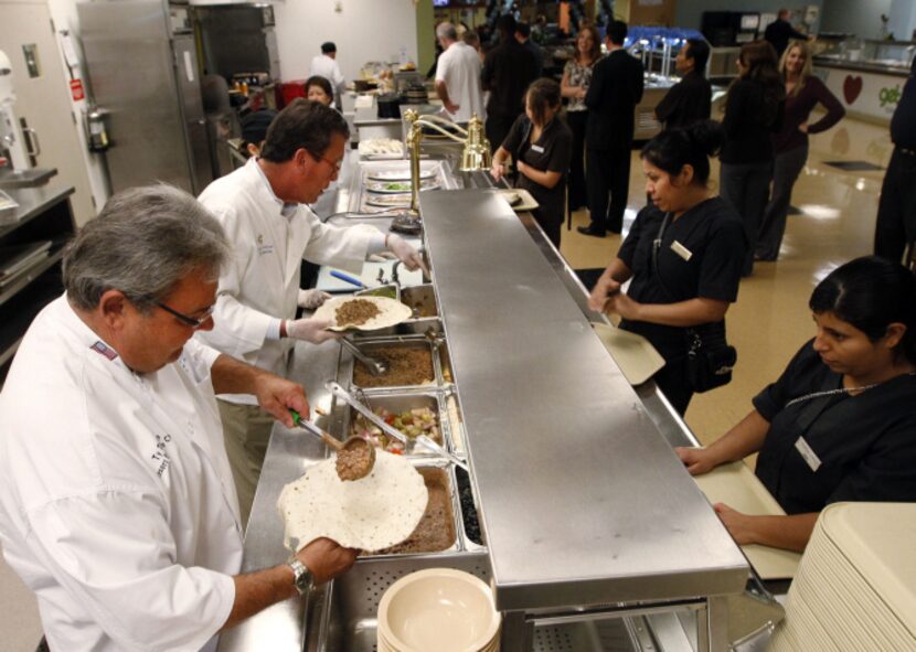 Ty Thoren, left, and Rick Ricci serve lunch to fellow employees at the Gaylord Texan Resort...